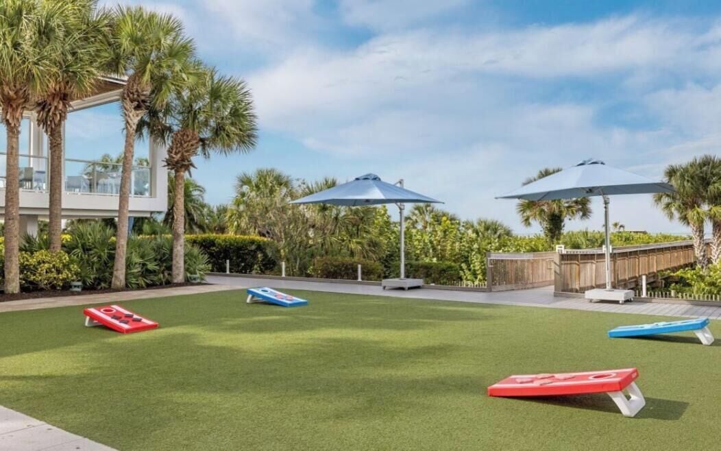 A well-maintained outdoor area with artificial grass, outdoor furniture, and umbrellas.