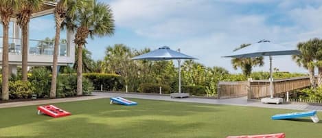 A well-maintained outdoor area with artificial grass, outdoor furniture, and umbrellas.