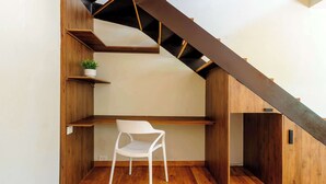 Ein modernes Interieur mit einer Holztreppe, eingebauten Regalen und einem weißen Stuhl.