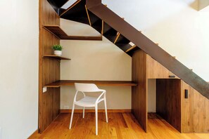 A modern interior with a wooden staircase, built-in shelves, and a white chair. - w* | Deluxe 1BR  Duplex in Prime Polanco (Ciudad de México)