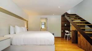 Ein modernes Schlafzimmer mit einem großen Bett, einer Holztreppe und einem weißen Stuhl.
