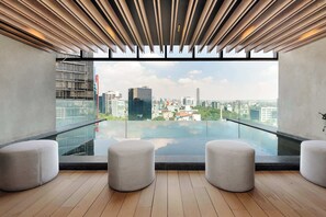 Ein modernes Interieur mit einem Glasbalkon mit Blick auf eine Stadtlandschaft.