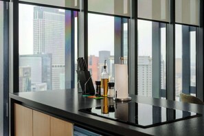 A modern kitchen with a black countertop, a knife block, a bottle of olive oil, and a roll of paper towels. - w* | Stylish 1BR in Juarez (Ciudad de México)