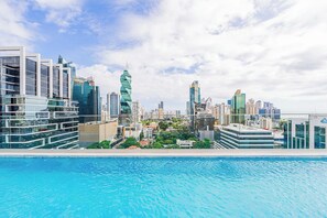 Paisagem urbana com edifícios modernos e piscina em primeiro plano.