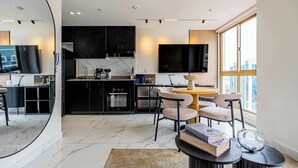 A modern kitchen with a dining area, a large window, and a flat-screen TV. - w* | Upscale 1BR in Obarrio w/ AC (Panamá)