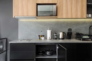 A modern kitchen with a microwave, a kettle, a coffee maker, and a range hood. - w* | Sunlit Loft in Tabacalera w/ Private Terrace (Ciudad de México)