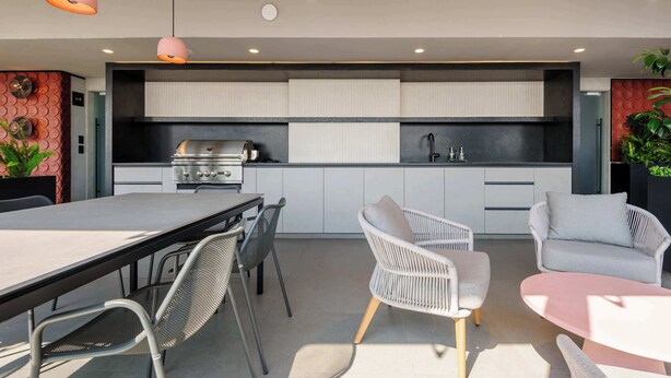 A modern kitchen with a built-in stove, white cabinets, and a dining area with wicker chairs and a table. - w* | Sunlit Loft w/ Private Terrace in Tabacalera (Ciudad de México)