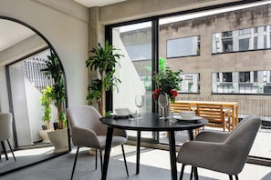 A modern dining area with a round table, two chairs, and a potted plant. - w* | Sunlit Loft in Tabacalera w/ Private Terrace (Ciudad de México)