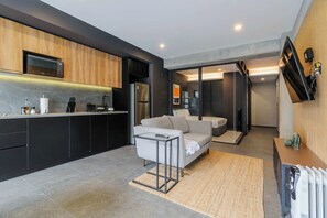 A modern kitchen with dark cabinetry, a built-in oven, and a stainless steel refrigerator. - w* | Sunlit Loft in Tabacalera w/ Private Terrace (Ciudad de México)