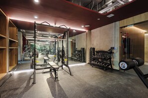 A gym with weightlifting equipment, benches, and a mirrored wall. - w* | Sunlit Loft w/ Private Terrace in Tabacalera (Ciudad de México)