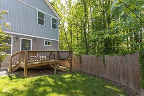 A two-story house with a wooden deck and a fenced backyard. - Asheville Oasis! 3BR home w/hot tub, fire pit, & game room only 6M from downtown (Asheville)