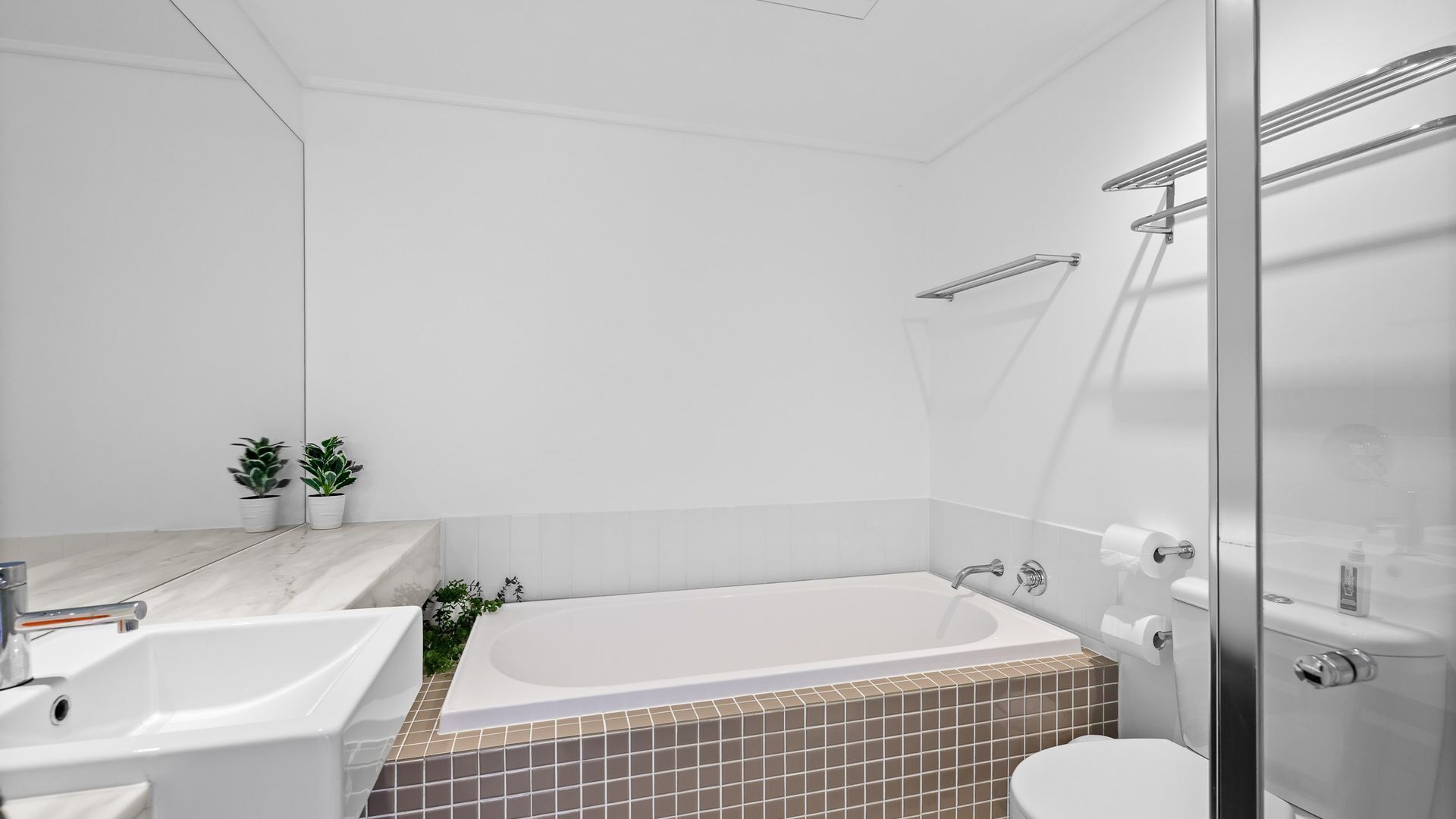 Une salle de bain moderne avec une baignoire, des toilettes et deux lavabos.