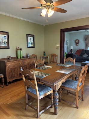 A dining room with a wooden table, chairs, and a ceiling fan.