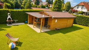 A wooden outdoor structure with a roof, a barbecue grill, and a seating area with a table and chairs. - Holiday Homes for 5 People Near the sea (Kamien Pomorski)