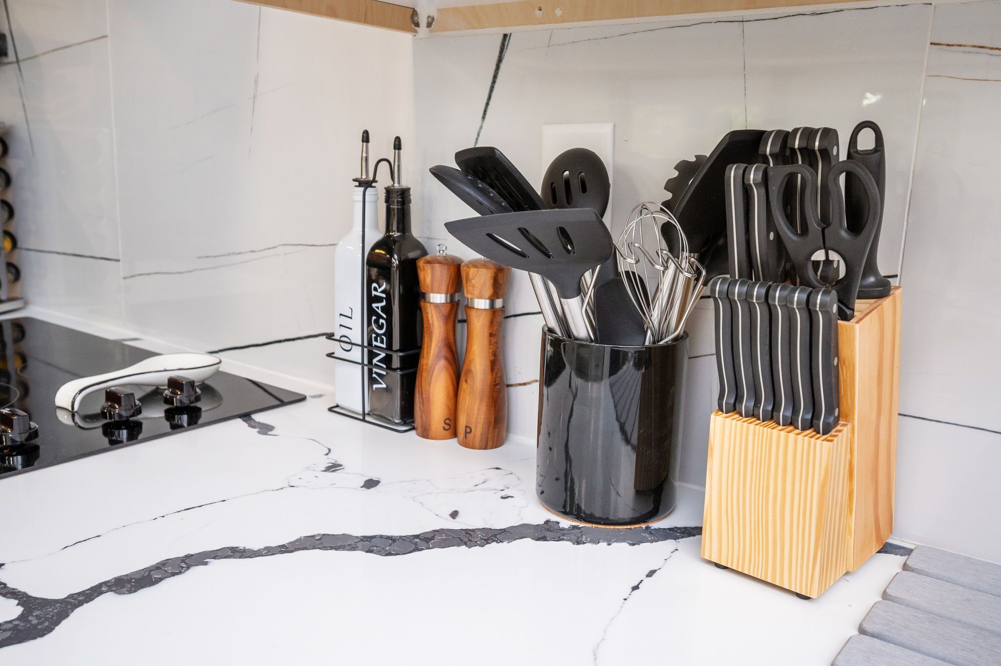 Eine Küchenarbeitsplatte mit Flaschenhalter, Pfefferstreuern und einem Messerblock.