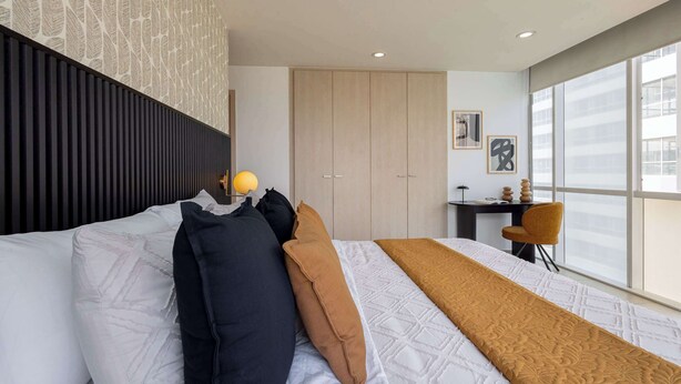 A modern hotel room with a large bed, a desk, and a chair. - Casa Azul Sky Residence | Above Polanco |Sleeps 10 (Mexico City)