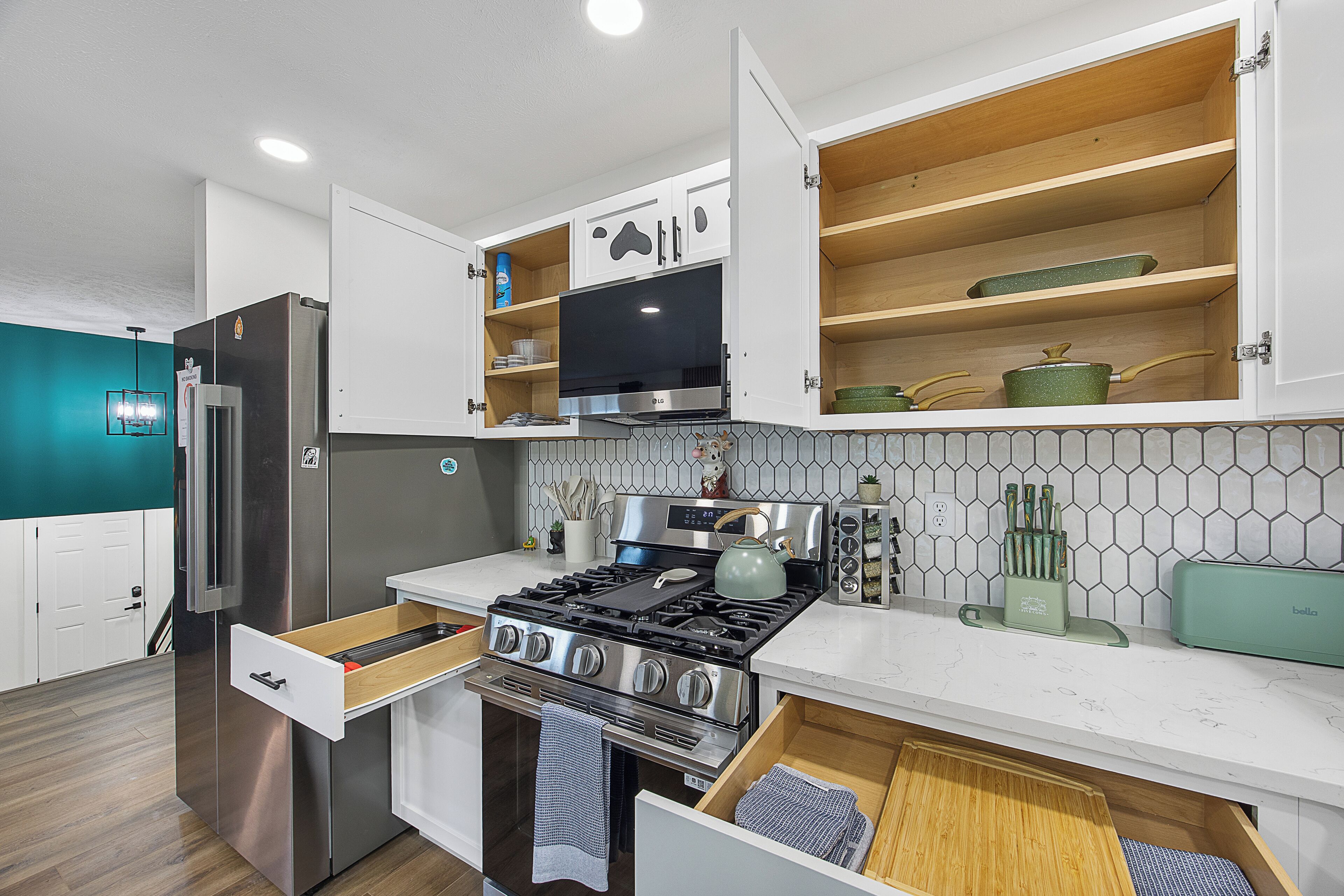 Une cuisine moderne dotée d’appareils électroménagers intégrés, de meubles en bois et d’un dosseret carrelé.