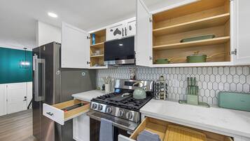 Une cuisine moderne dotée d’appareils électroménagers intégrés, de meubles en bois et d’un dosseret carrelé.