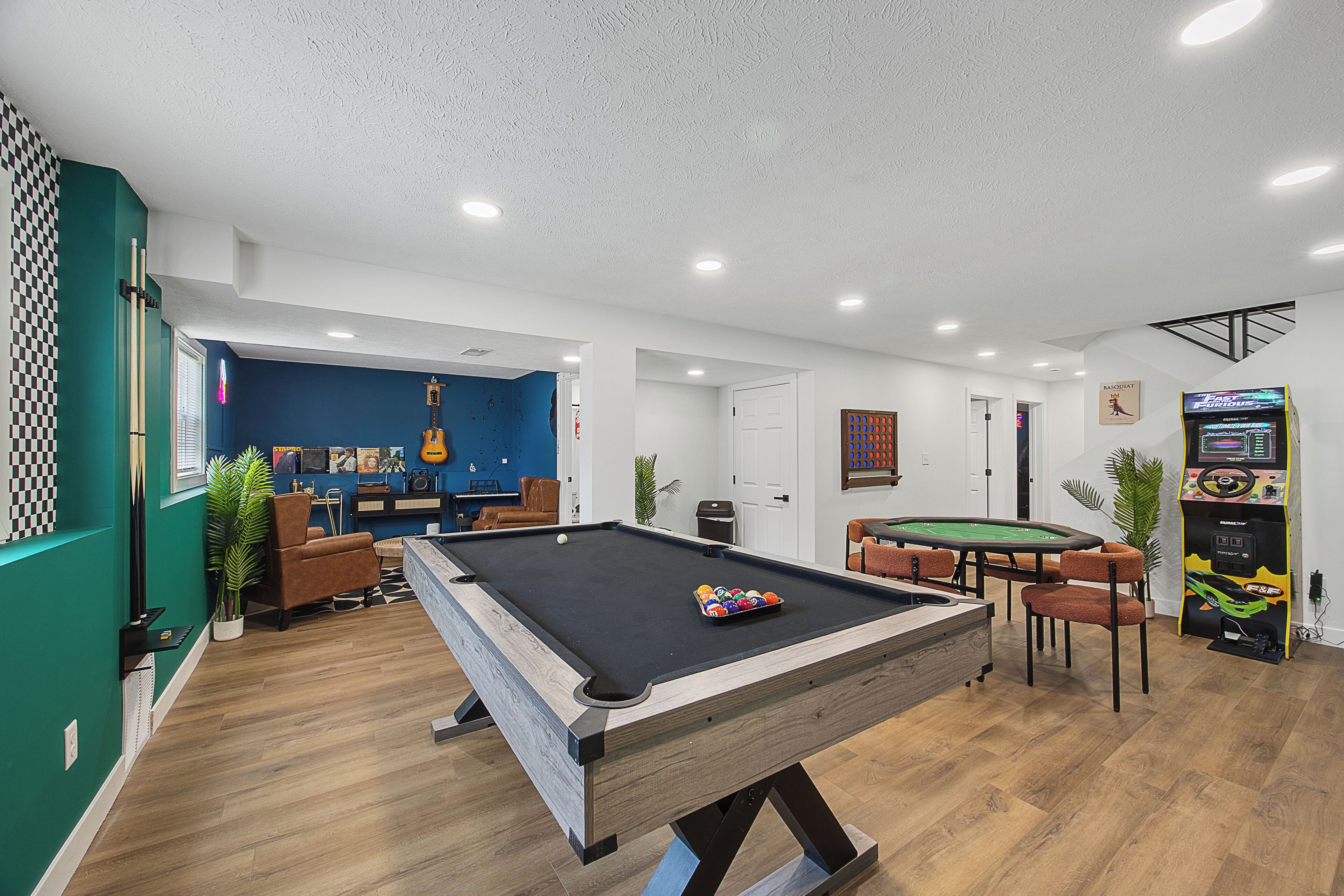 Ein Billardtisch in einem Raum mit blauer Wand, einer Gitarre und einem Spieltisch.