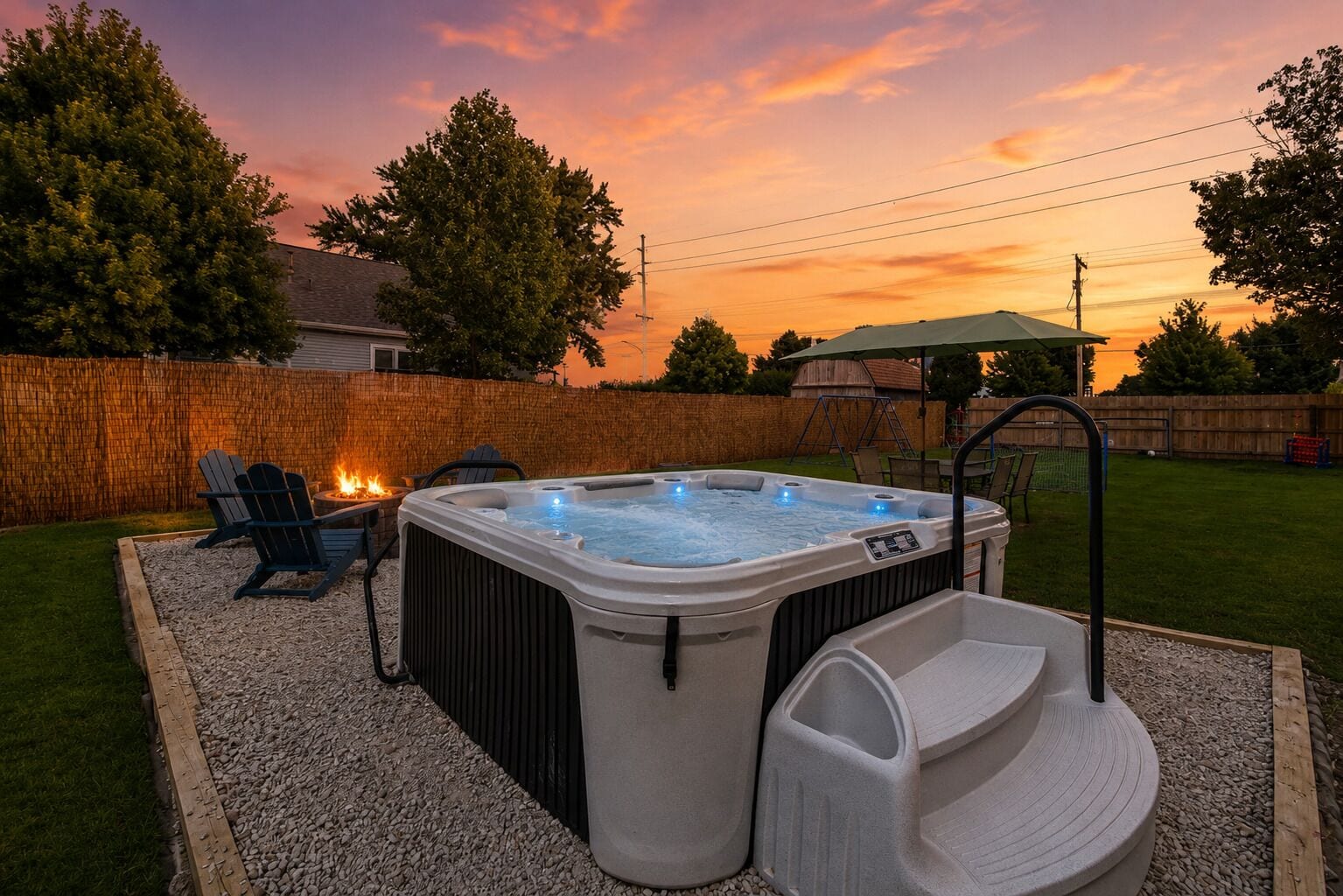 Un jacuzzi con asiento incorporado, rodeado por una terraza de madera y un hogar para fuego.
