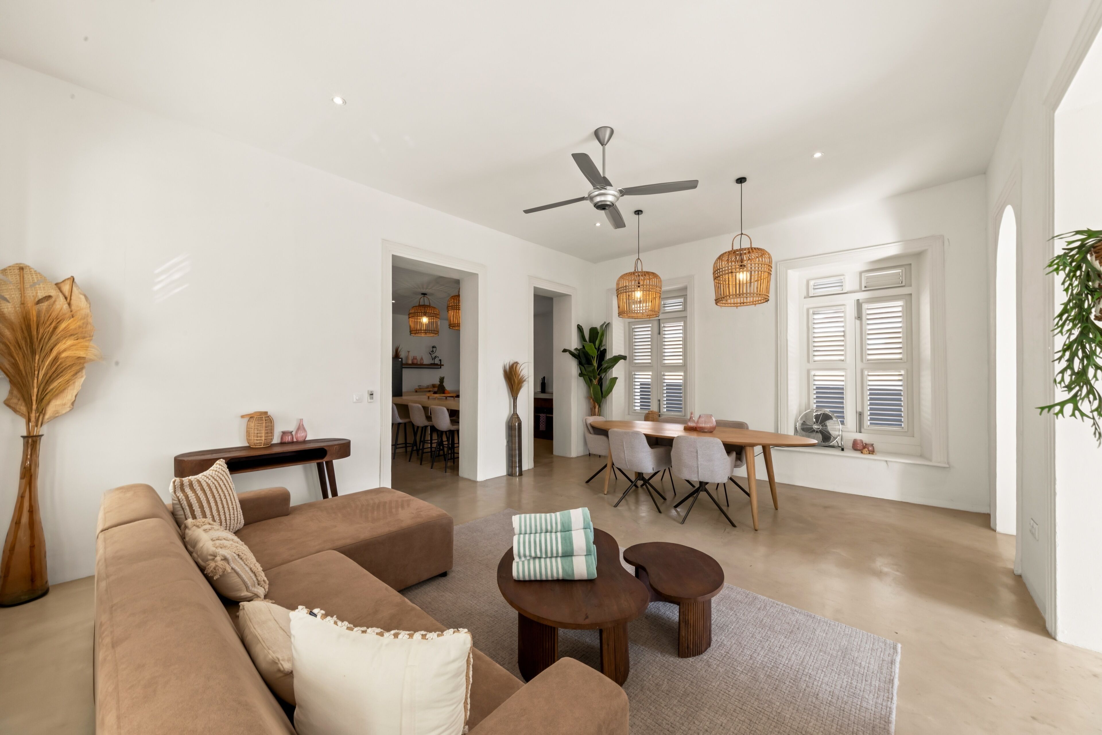 A spacious living area with a sofa, coffee table, and dining table.