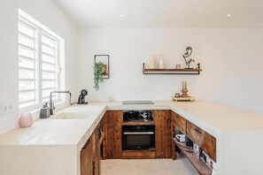 Una cocina moderna con horno empotrado, cafetera y un mueble de madera.