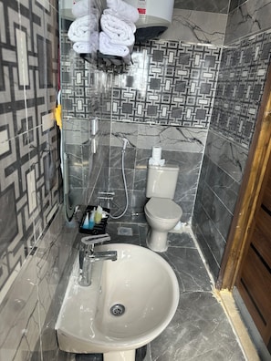 Ein Badezimmer mit Waschbecken, Toilette und Handtuchhalter.