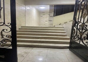 Eine Treppe mit Handlauf und einem Metallgitter.