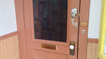 A brown door with a glass panel, a keypad lock, and a mailbox.