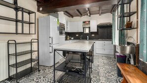 Una cocina moderna con una isla central, electrodomésticos integrados y suelo estampado.