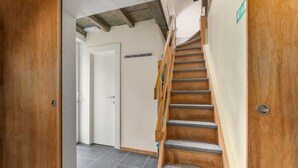 Una escalera de madera con peldaños alfombrados que conduce a una puerta.