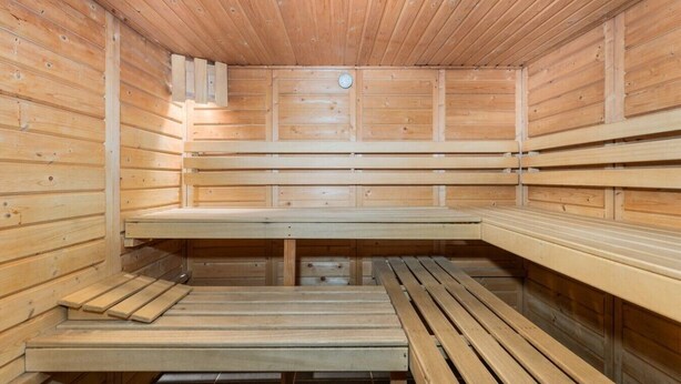 A sauna with wooden benches and a central bench.