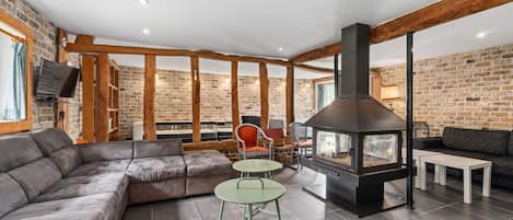 Una sala moderna con chimenea, zona de estar y paredes de ladrillo visto.