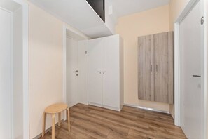 Ein Flur mit Holzboden, weißen Wänden und einem Holzschrank.