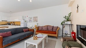Una sala de estar moderna con un sofá, una mesa de centro y una televisión.