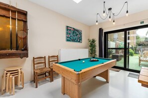 A pool table in a room with a view of the outdoors, wooden chairs, and a painting on the wall. - Barbara`s Guesthouse (Poperinge)