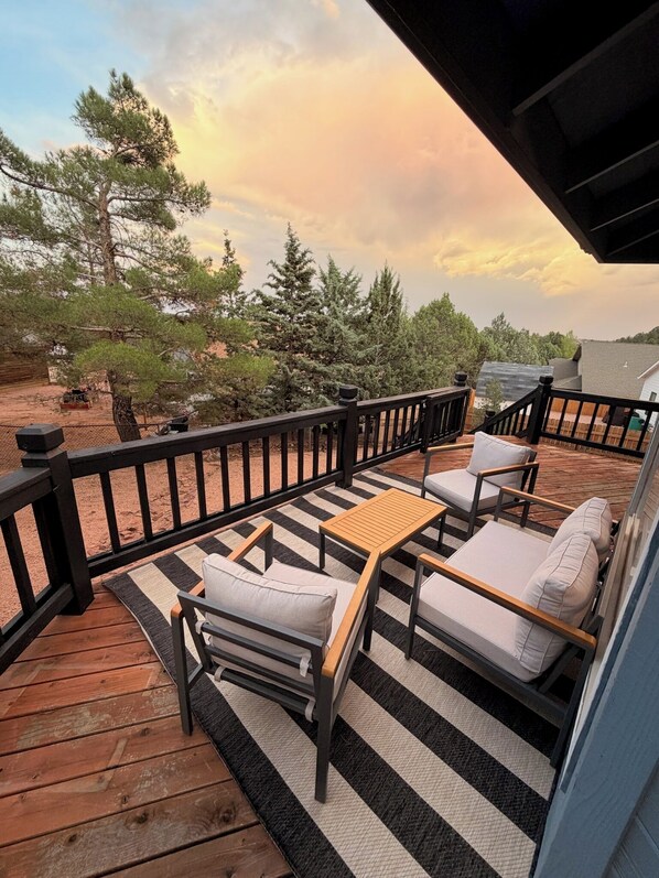 A wooden deck with outdoor furniture, a railing, and a view of trees and a distant building. - The Pine Loft, Spacious Mountain Escape in Payson (Payson)