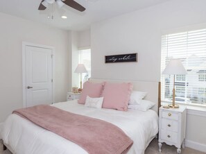 A bedroom with a bed, a nightstand, a wall clock, and a window with blinds. - Rebel'ado-Colorado Roots-Oxford Style! 3 King Ensuites -Sleeps 8 (Oxford)