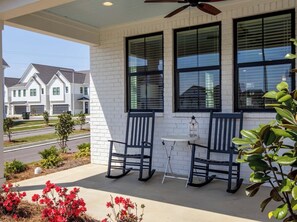 A covered porch with two rocking chairs, a small table, and a ceiling fan. - Rebel'ado-Colorado Roots-Oxford Style! 3 King Ensuites -Sleeps 8 (Oxford)