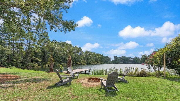 A lakeside outdoor seating area with Adirondack chairs and a fire pit. - Stillwater Cottage - Dock + Fishing (Brunswick)