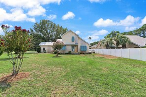 A two-story house with a front yard, a small tree, and a white fence. - Stillwater Cottage - Dock + Fishing (Brunswick)