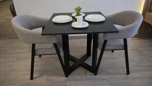 A dining table with two chairs, a small potted plant, and white plates. - Colonia10 by tuhost (Monterrey)