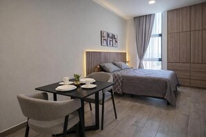 A modern hotel room with a bed, a dining table with chairs, and a small table with a plant. - Colonia10 by tuhost (Monterrey)