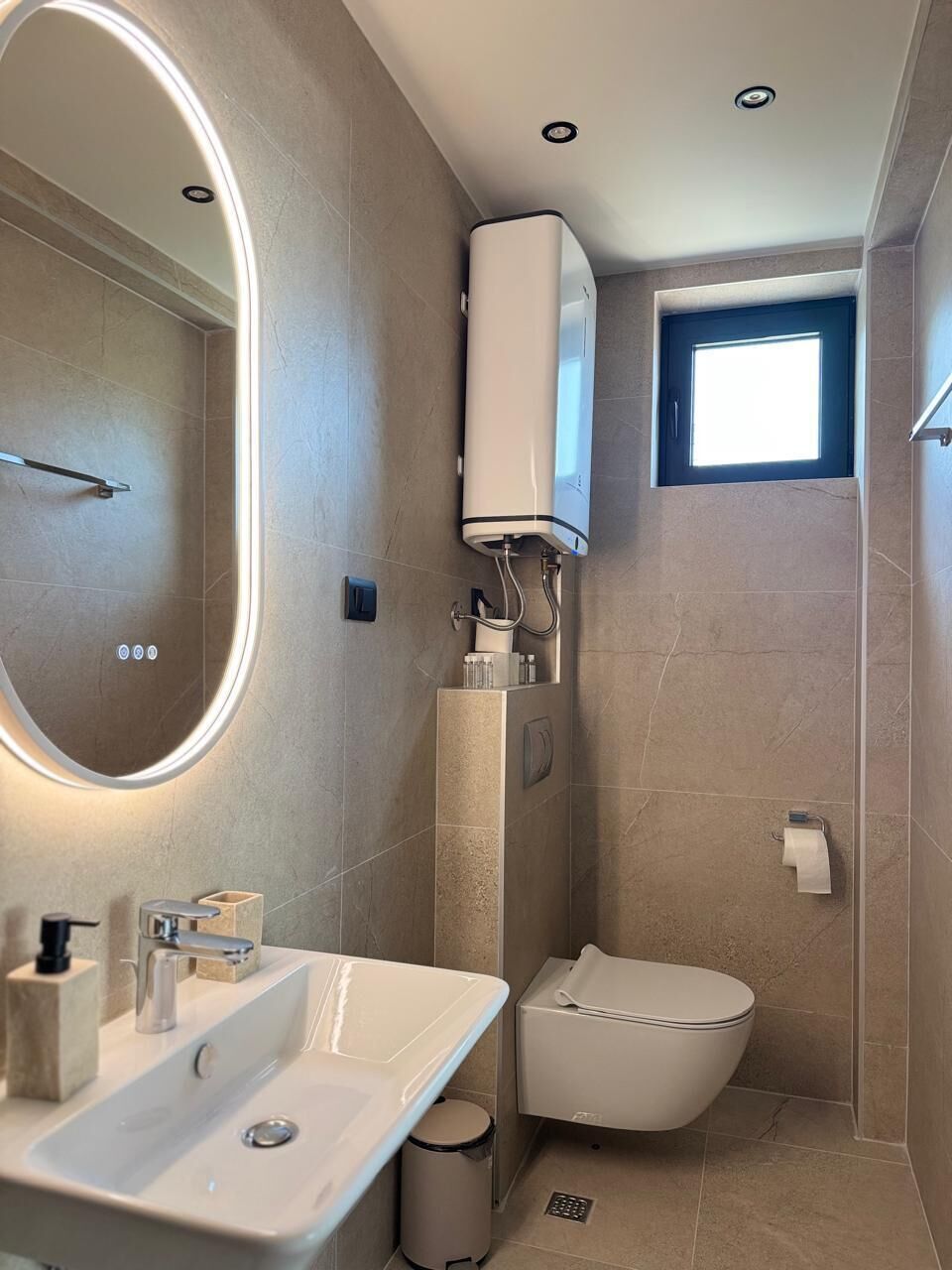 A modern bathroom with a built-in sink, a toilet, and a shower area.