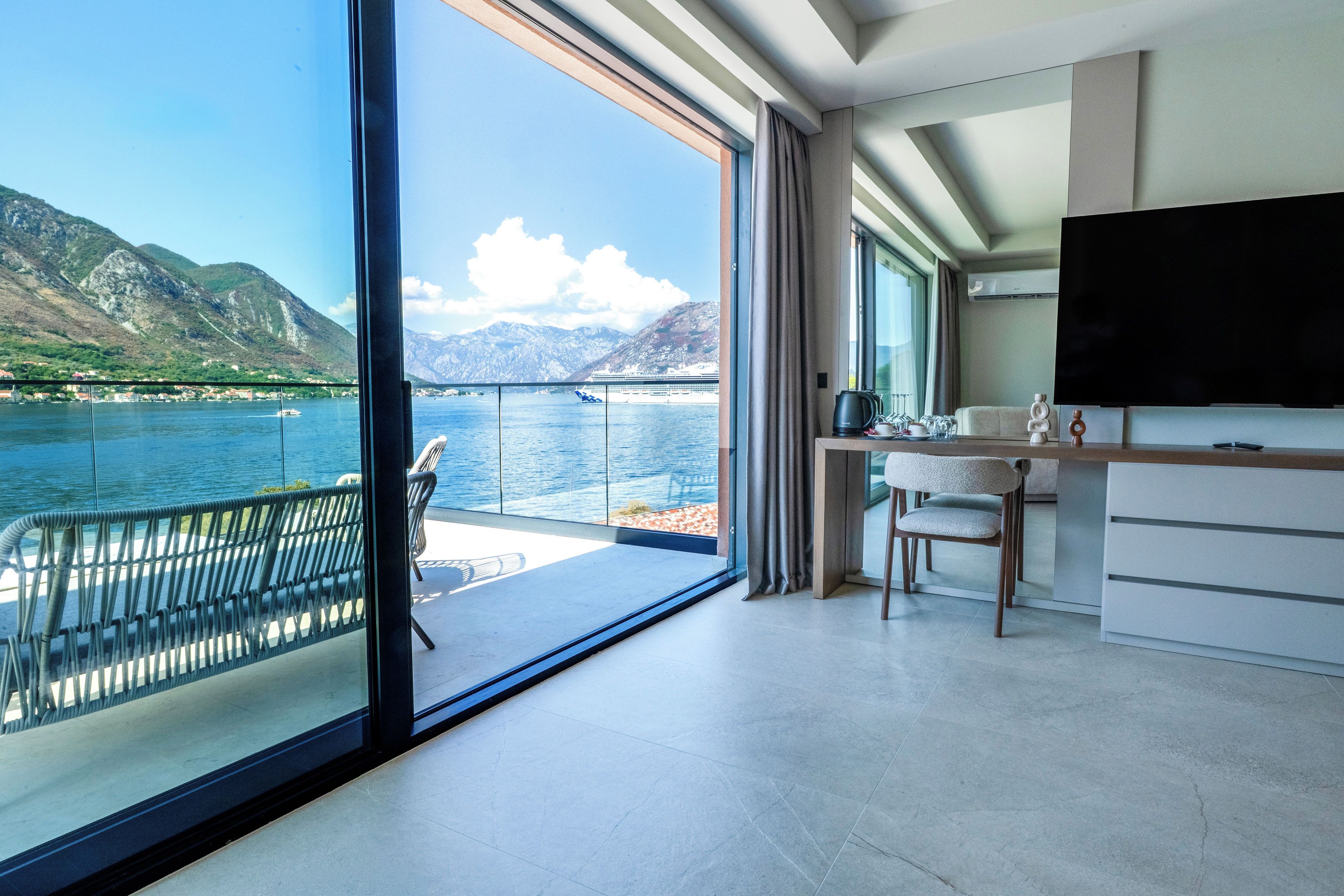 A modern interior with a large window offering a view of a lake and mountains.