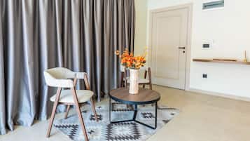 Ein Zimmer mit einem runden Tisch, zwei Stühlen, einer Vase mit Blumen und einer Tür.