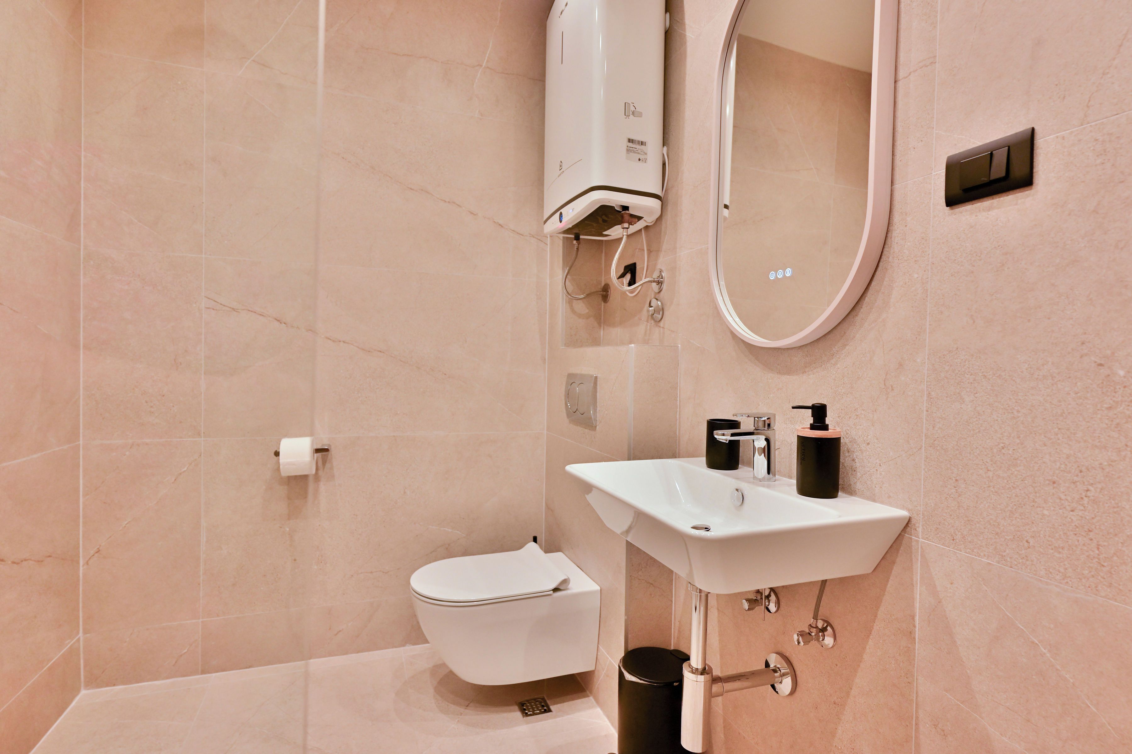 Ein modernes Badezimmer mit Toilette, Waschbecken und Spiegel.