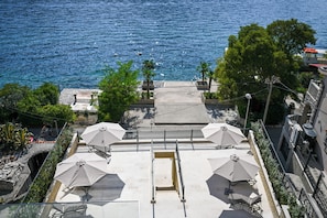 A terrace with outdoor seating and a view of the sea.