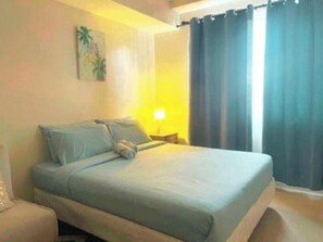Ein Hotelzimmer mit einem Bett, einem Nachttisch und einem Bild an der Wand.