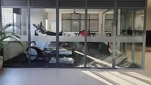 A modern interior with a large sliding glass door leading to a room with exercise equipment. - Cozy Retreat by Jane, UNIT 626 (Cebu City)